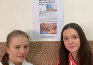 Kasia i Natalka przy plakcie szkolnym promujacym ich projekt